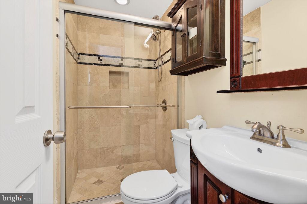8471 Great Lake Lane Springfield, VA 22153 - Photo 21 of 65 a bathroom with a sink a toilet and shower