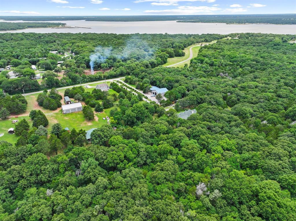 207 Paradise Park Road Pottsboro, TX 75076 - Photo 25 of 28 Expansive aerial view showcasing a large body of water, extensive wooded acreage, and multiple buildings