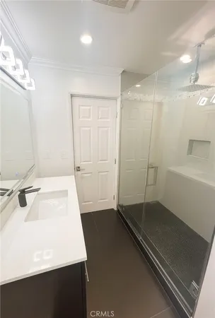 a bathroom with a sink a mirror and a shower