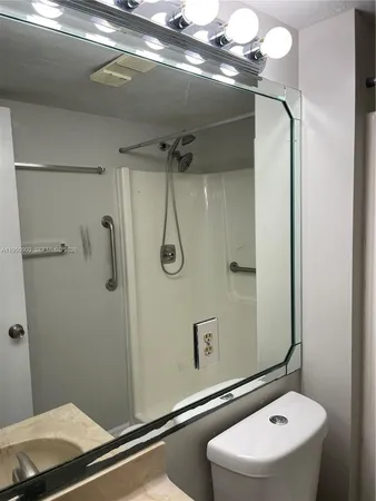 a bathroom with a sink a toilet and shower