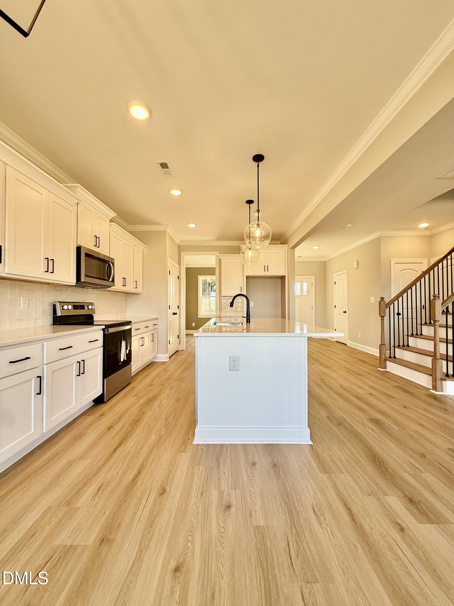 6862 Fire Tower Road Spring Hope, NC 27882 - Photo 13 of 35 a view of a kitchen with kitchen island a sink wooden floor and stainless steel appliances