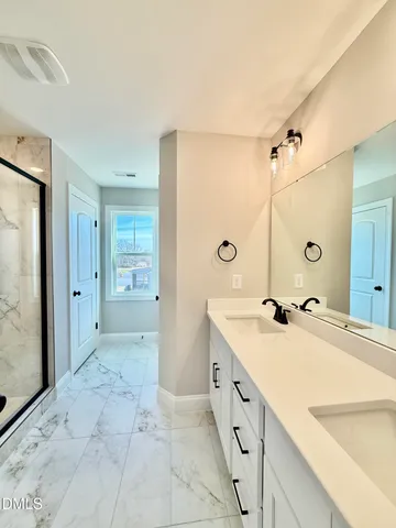 a spacious bathroom with a granite countertop sink mirror and a shower