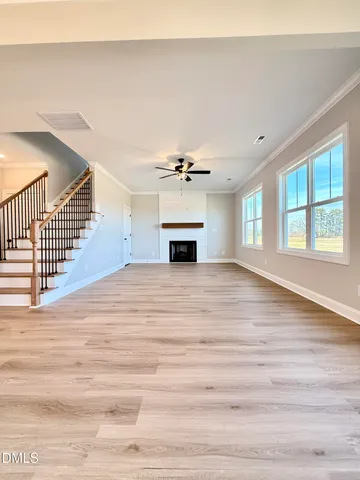 a view of a livingroom with a ceiling fan window and wooden floor