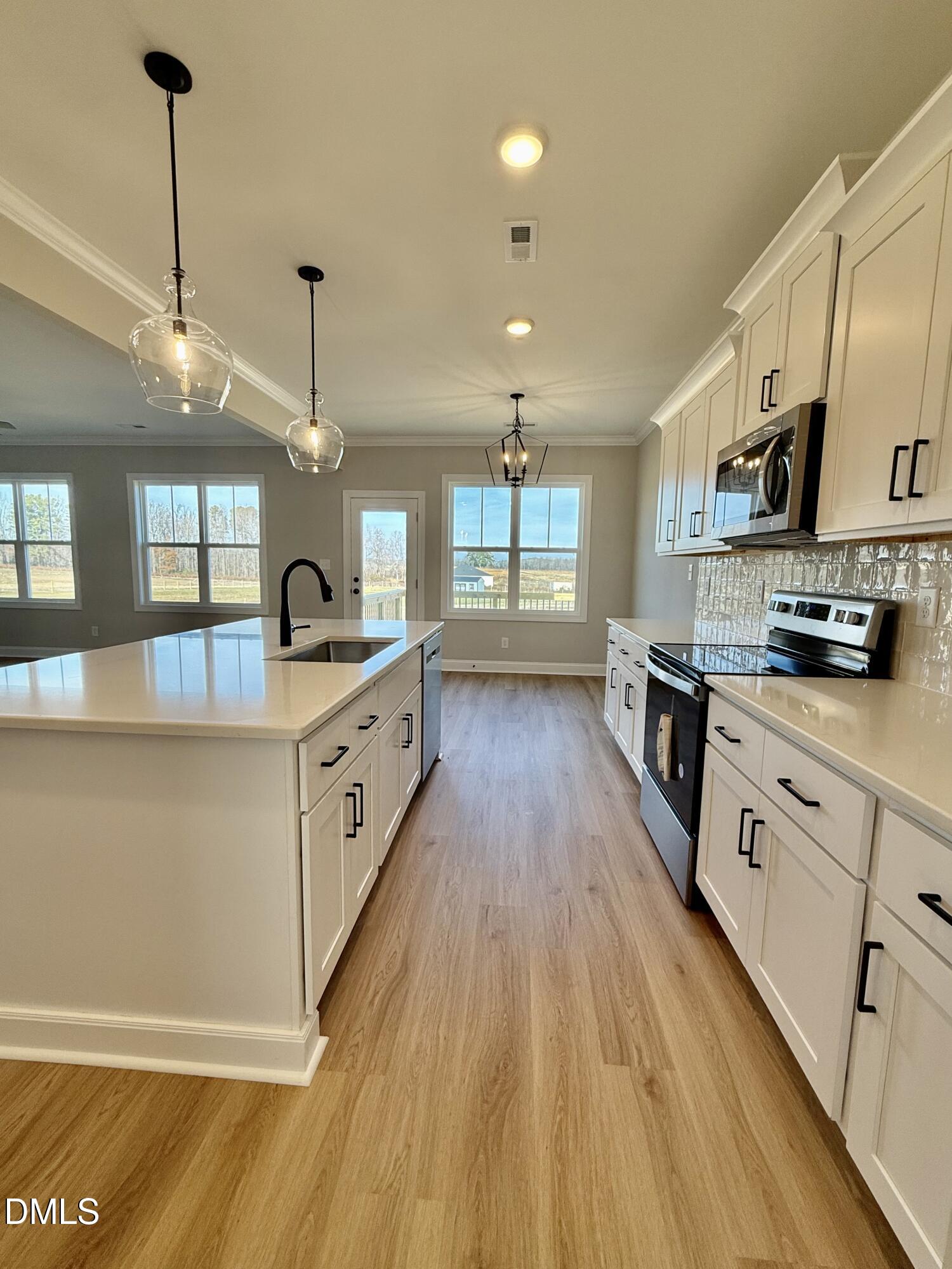 6862 Fire Tower Road Spring Hope, NC 27882 - Photo 8 of 35 a large kitchen with stainless steel appliances granite countertop a lot of counter space and wooden floors