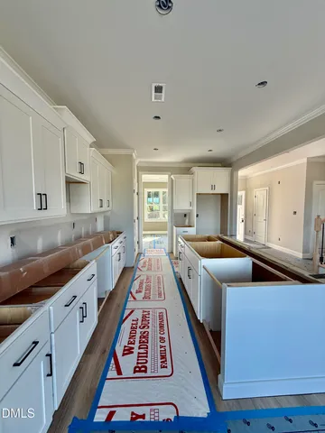 a large kitchen with stainless steel appliances granite countertop a lot of counter space and wooden floor