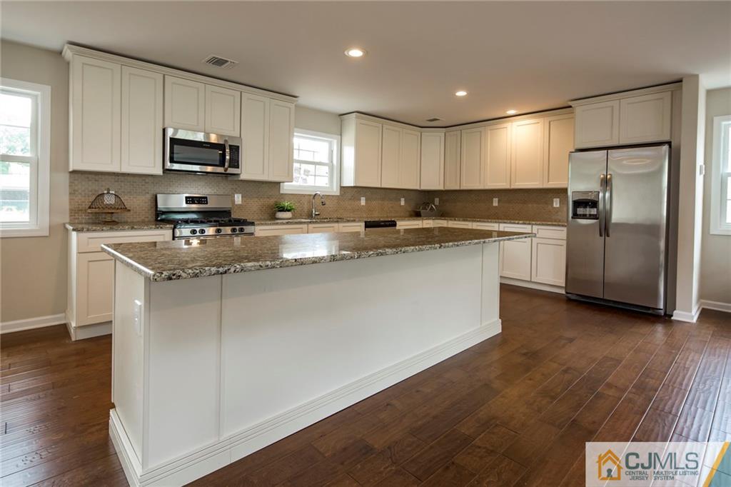 44 Caldwell Road Edison, NJ 08817 - Photo 11 of 25 a kitchen with stainless steel appliances granite countertop a refrigerator a sink dishwasher a stove top oven a refrigerator and white cabinets with wooden floor