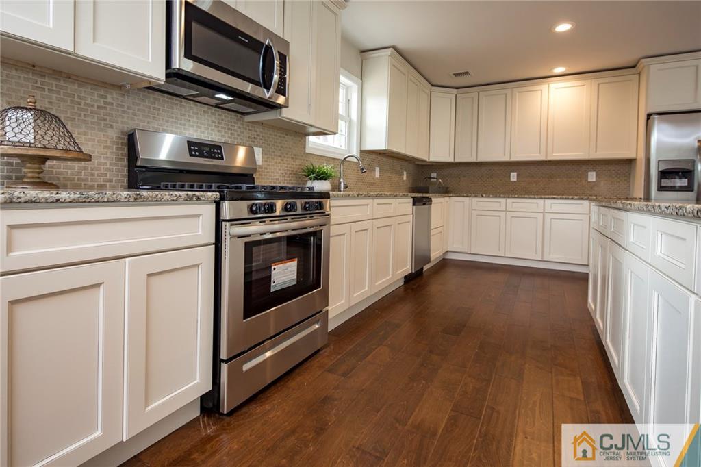 44 Caldwell Road Edison, NJ 08817 - Photo 14 of 25 a kitchen with stainless steel appliances granite countertop a stove a sink and a microwave