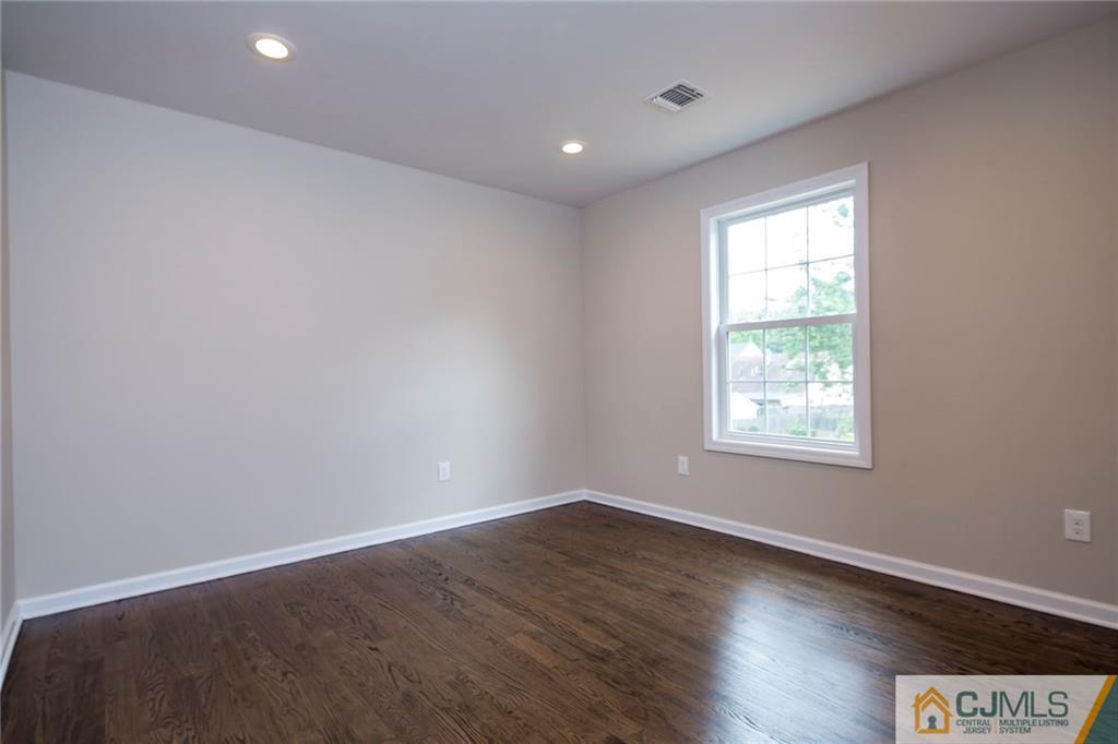 44 Caldwell Road Edison, NJ 08817 - Photo 18 of 25 an empty room with wooden floor and windows