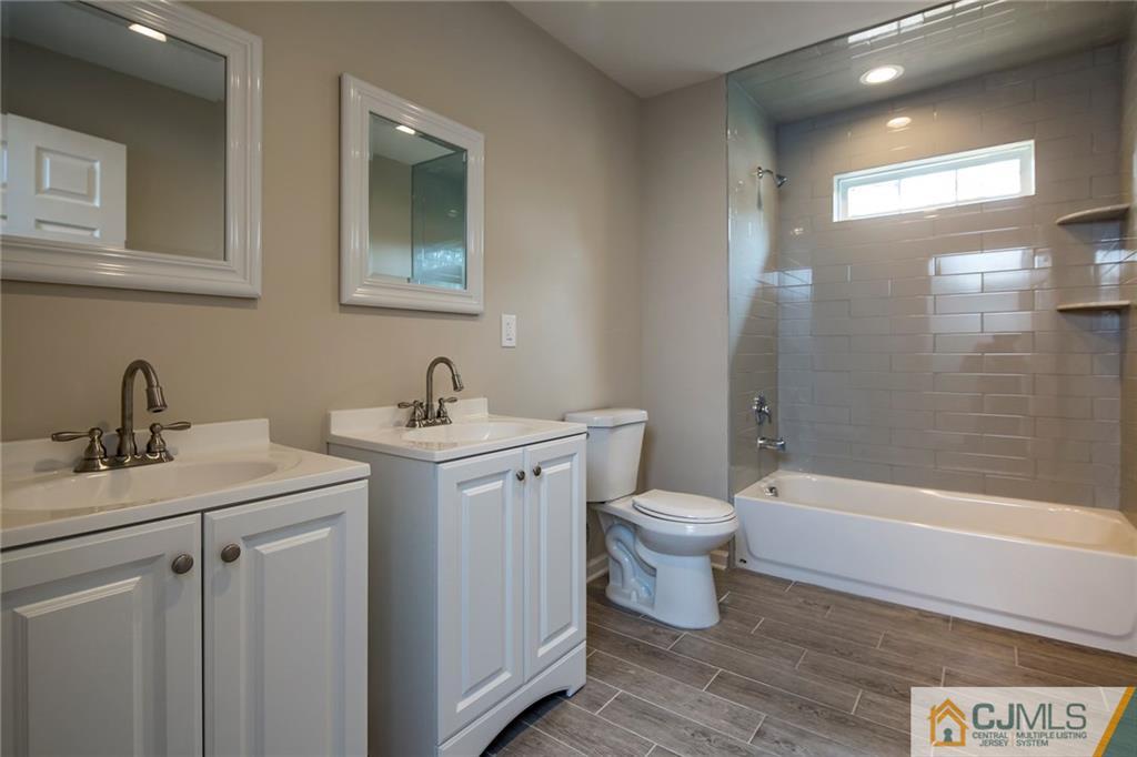 44 Caldwell Road Edison, NJ 08817 - Photo 19 of 25 a bathroom with a toilet a sink a mirror a bathtub and vanity