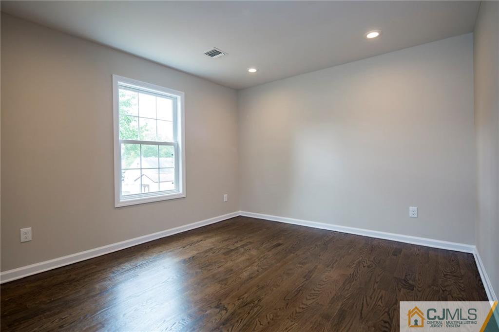 44 Caldwell Road Edison, NJ 08817 - Photo 20 of 25 an empty room with wooden floor and windows