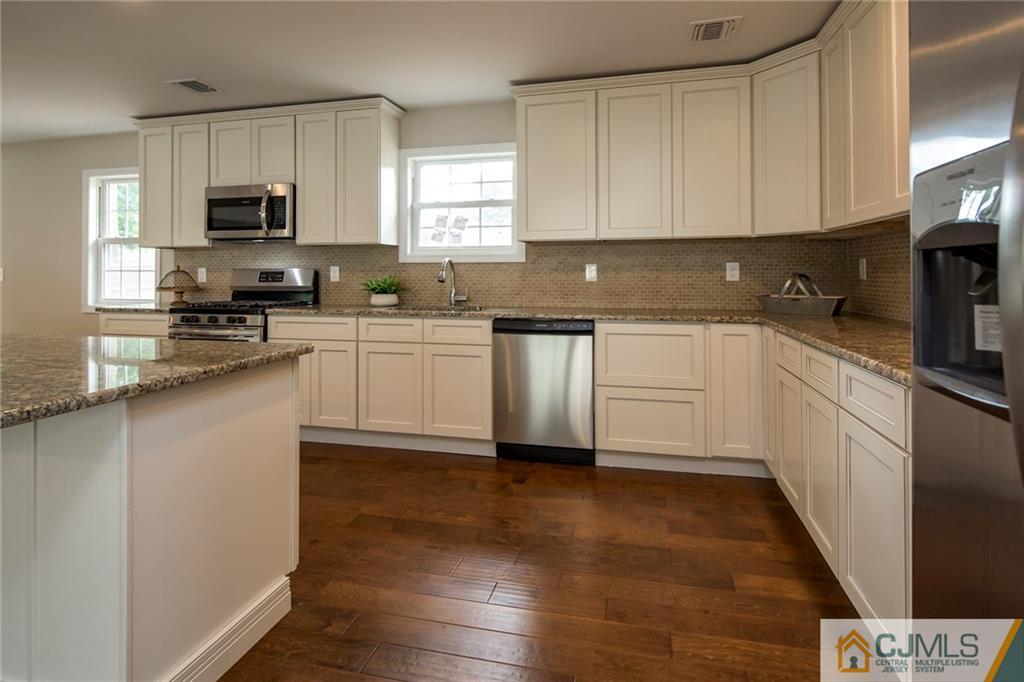 44 Caldwell Road Edison, NJ 08817 - Photo 10 of 25 a kitchen with granite countertop cabinets stainless steel appliances a sink and a window