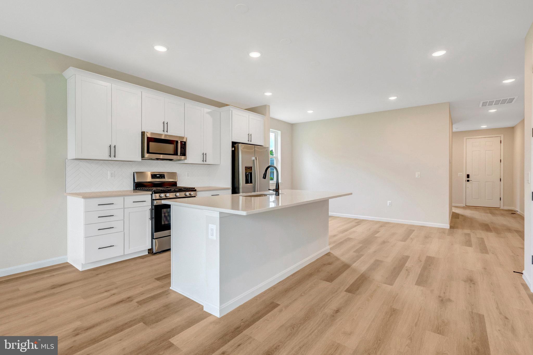 100 Midsummer Lane Middletown, VA 22645 - Photo 16 of 47 a kitchen with white cabinets stainless steel appliances and a sink
