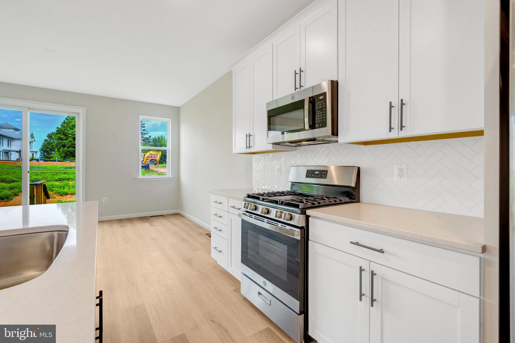 100 Midsummer Lane Middletown, VA 22645 - Photo 18 of 47 a kitchen with stainless steel appliances white cabinets and a stove top oven