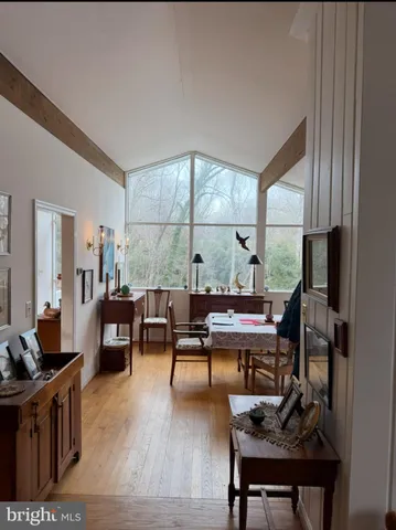 a work room with furniture a large window and wooden floor