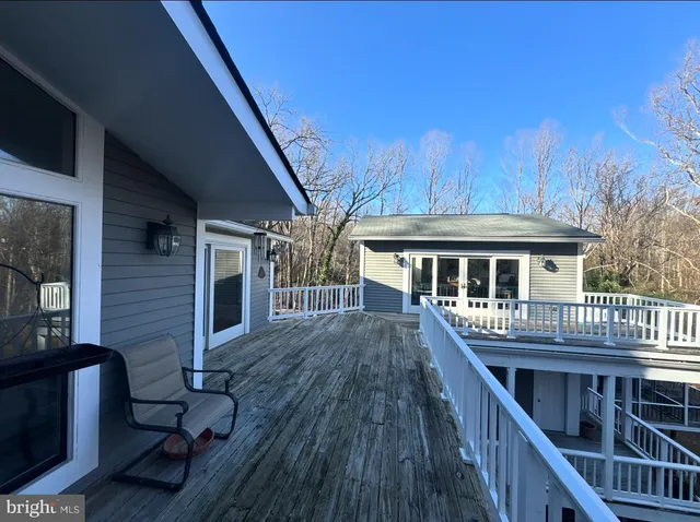 a front view of house with deck and seating space