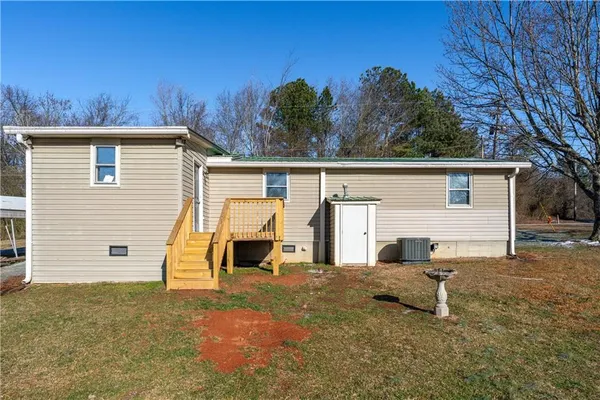 a view of a house with backyard and a tree