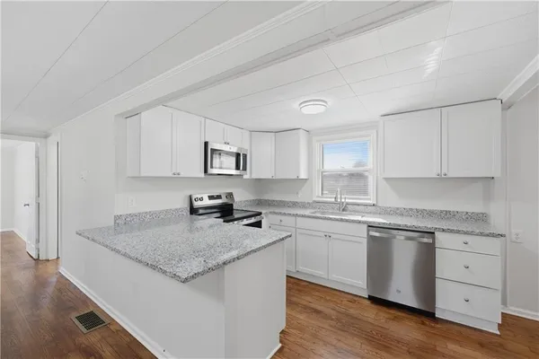 a kitchen with granite countertop white cabinets and white appliances