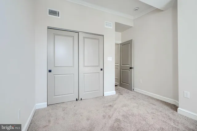 a bedroom with a bed lamp closet and large window