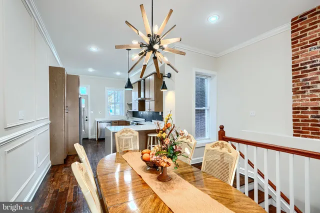 a kitchen with stainless steel appliances a dining table and chairs