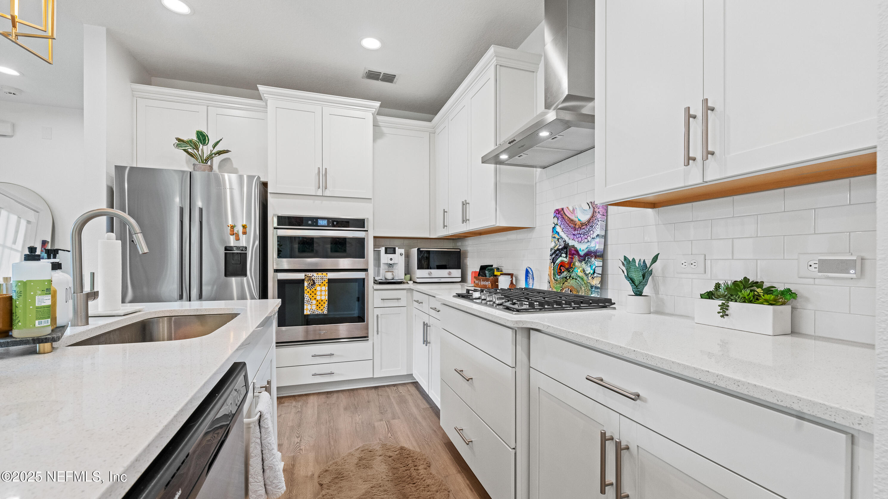 327 Charlie Way St. Augustine, FL 32095 - Photo 7 of 22 a kitchen with kitchen island white cabinets and stainless steel appliances