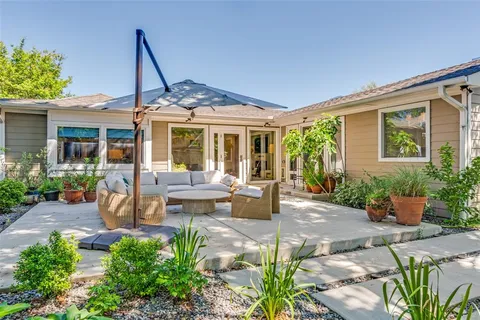 a view of a house with backyard sitting area and garden
