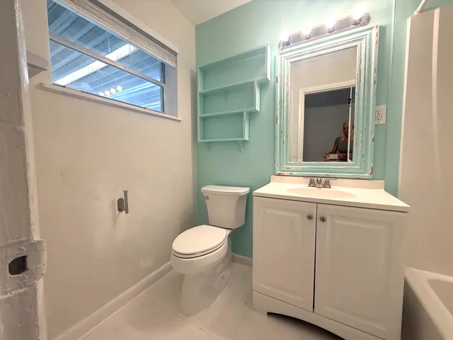 a bathroom with a toilet sink and mirror