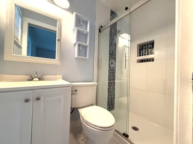 a bathroom with a sink mirror toilet and shower