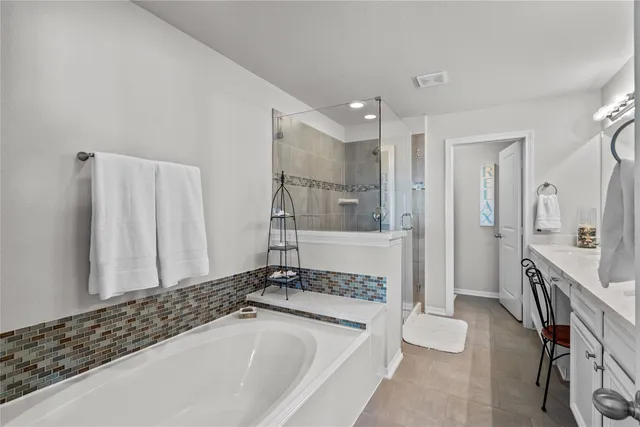 a spacious bathroom with a tub and a sink