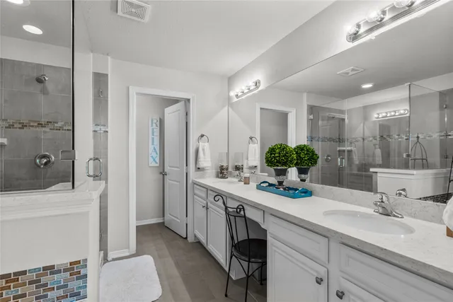 a bathroom with a sink double vanity granite tub and shower