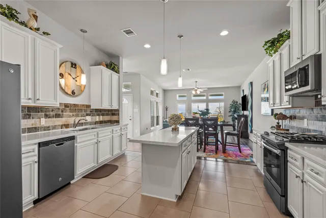 a kitchen with stainless steel appliances granite countertop a sink and a stove