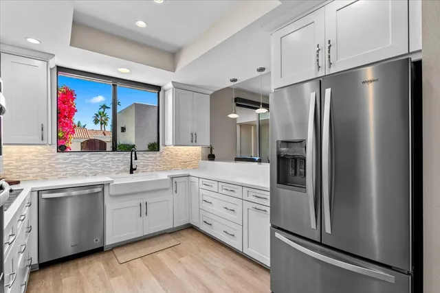 a kitchen with refrigerator cabinets and wooden floor