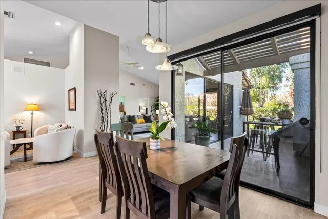 a dining room with furniture potted plants and wooden floor