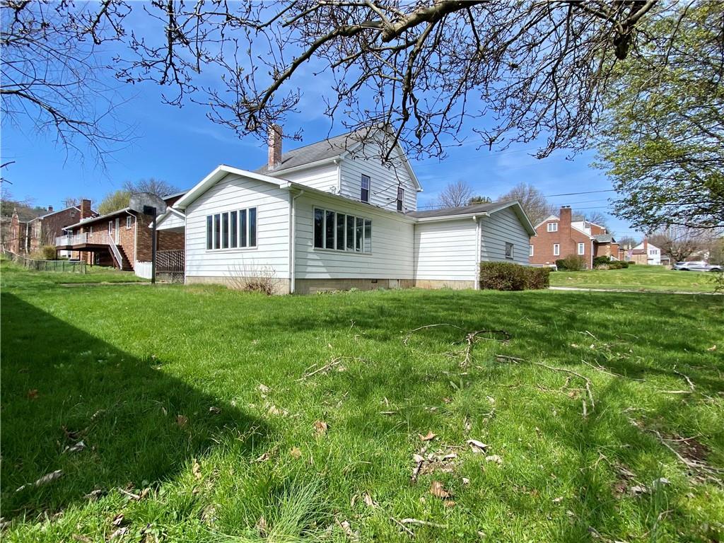 116 Nassau Street Uniontown, PA 15401 - Photo 25 of 25 a house that is sitting in the grass with large trees and plants