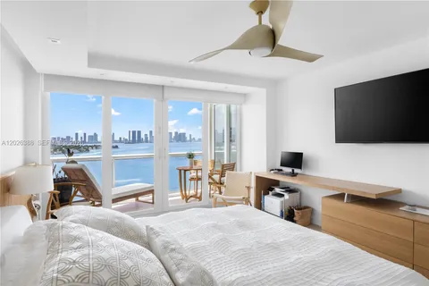 a spacious bedroom with a bed and a flat screen tv