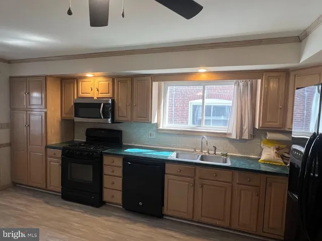 a kitchen with granite countertop a sink cabinets and stainless steel appliances