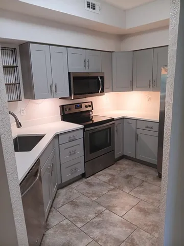 a kitchen with white cabinets a sink and white appliances