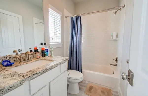 a bathroom with a granite countertop sink toilet and shower