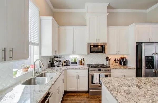 a kitchen with stainless steel appliances granite countertop a sink stove and refrigerator