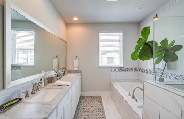a spacious bathroom with a granite countertop tub a sink and a window