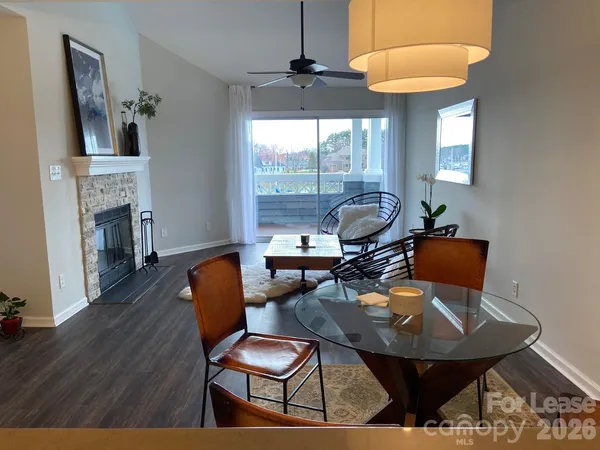 a dining room with furniture a fireplace and wooden floor