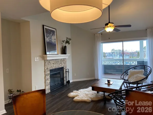 a living room with furniture a fireplace and a floor to ceiling window