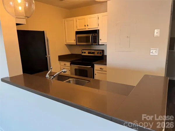 a living room with stainless steel appliances furniture a fireplace and a flat screen tv