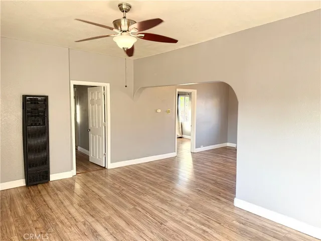 a view of an empty room with wooden floor