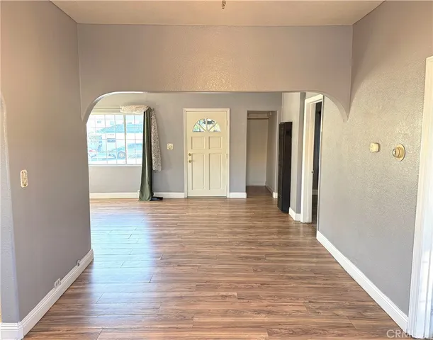 a view of a hallway with wooden floor and windows