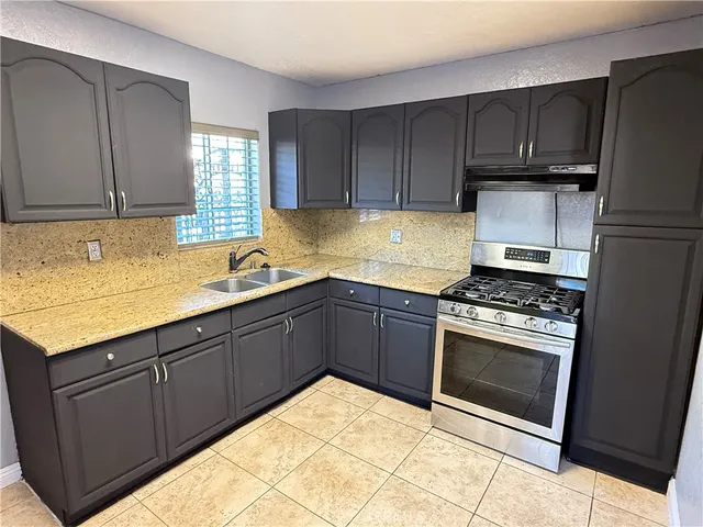 a kitchen with granite countertop wooden cabinets and stainless steel appliances