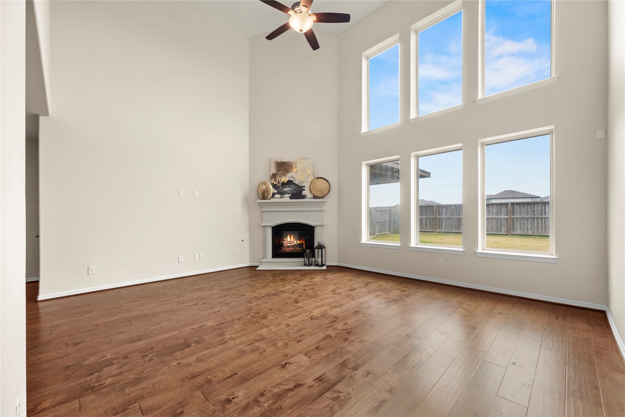 11734 Deepwater Ridge Way Cypress, TX 77433 - Photo 13 of 35 an empty room with wooden floor fireplace and windows
