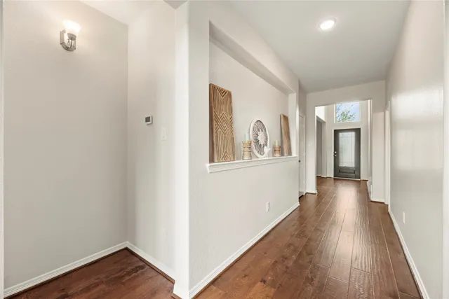 a view of a hallway with wooden floor and closet