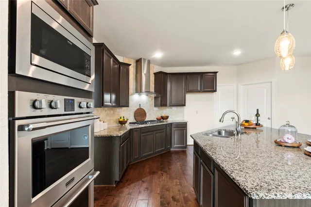 a kitchen with granite countertop stainless steel appliances and wooden cabinets