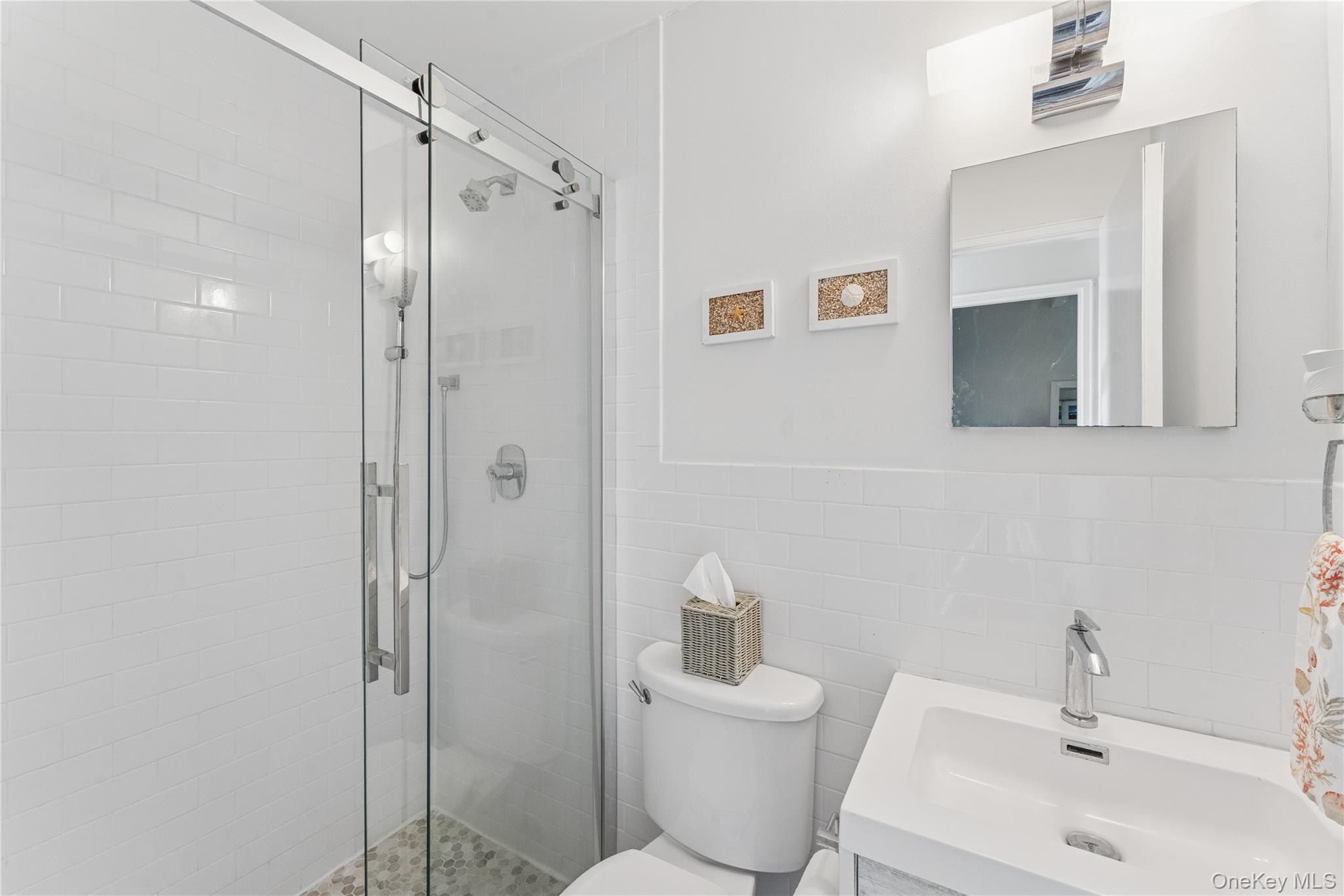 35 Library Avenue, Unit 3L Westhampton Beach, NY 11978 - Photo 10 of 12 a bathroom with a shower a sink and toilet