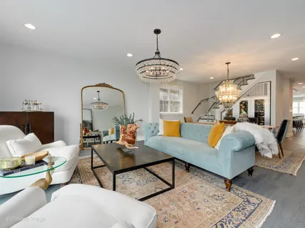 a living room with furniture a chandelier and a table